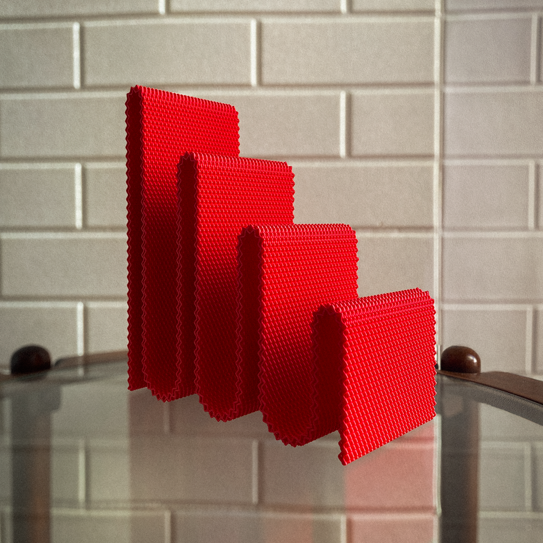 Coregrid Sinu Stand in Red – 3D printed sculptural book organiser with RippleMesh texture