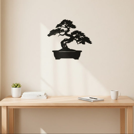 Black 3D printed bonsai tree wall art mounted on a warm cream wall above a natural wood desk with a succulent, stacked books, notebook and white ceramic mug, minimal home office, UK made