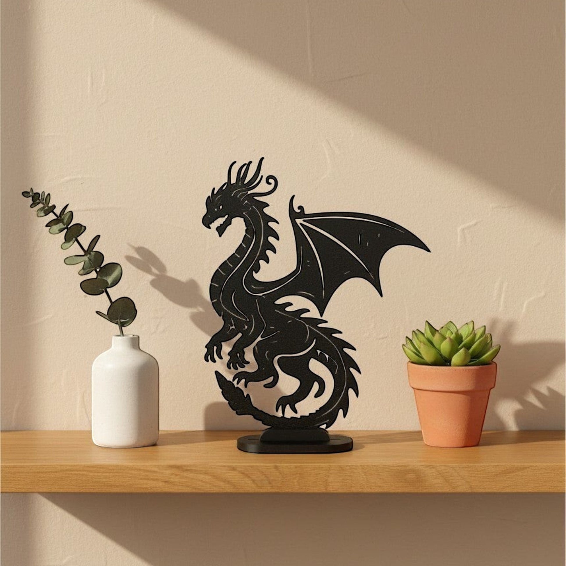 Matte charcoal flat display stand holding a black 3D printed dragon wall art piece on a wooden shelf, UK made