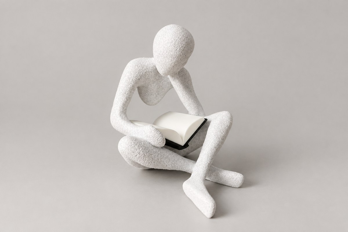 The Reader NObody sculpture in White Marble holding an open book, front view.